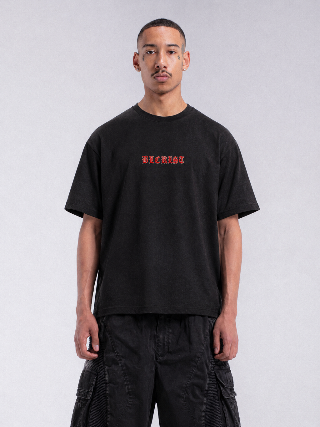 Front view of a black oversized Dealbreaker T-shirt featuring red gothic BLCKLST lettering on the chest