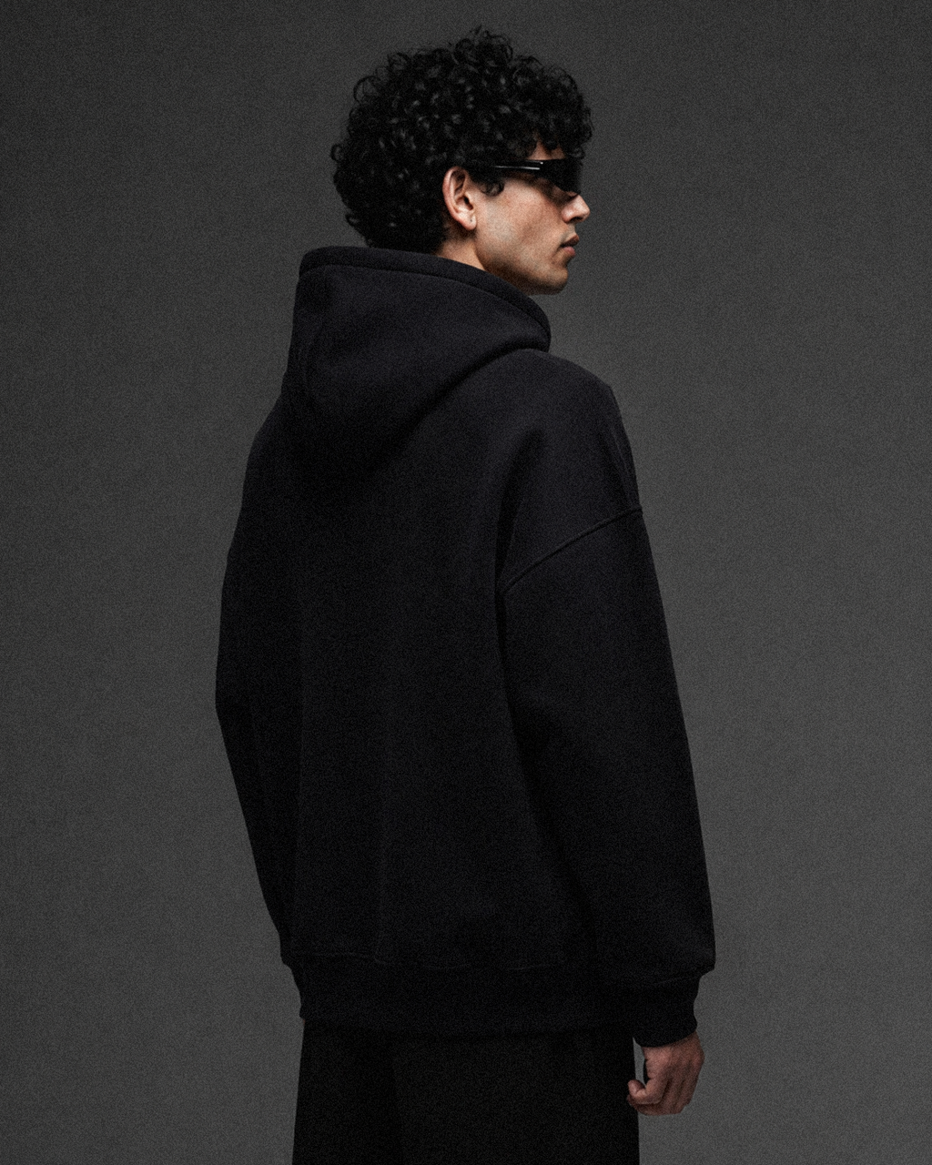 Black 350 GSM Basic Oversized Hoodie, side-back view showing the hood and oversized fit