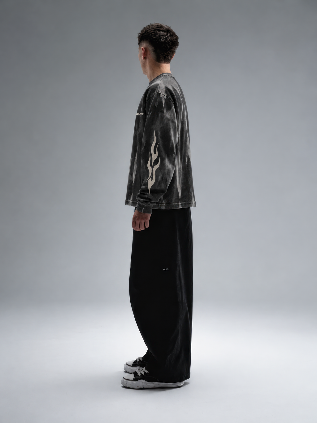 BLCKLST Forge Hammer Wash Waffle Full Sleeve T-Shirt 240 GSM, oversized black waffle knit streetwear tee with distressed grey hammer wash and tribal flame sleeve prints, side profile view.