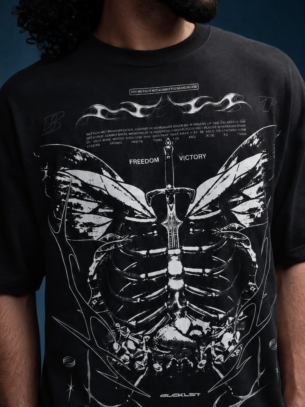 Close-up of Fly Me black oversized T-shirt with detailed anatomical sword and butterfly graphic